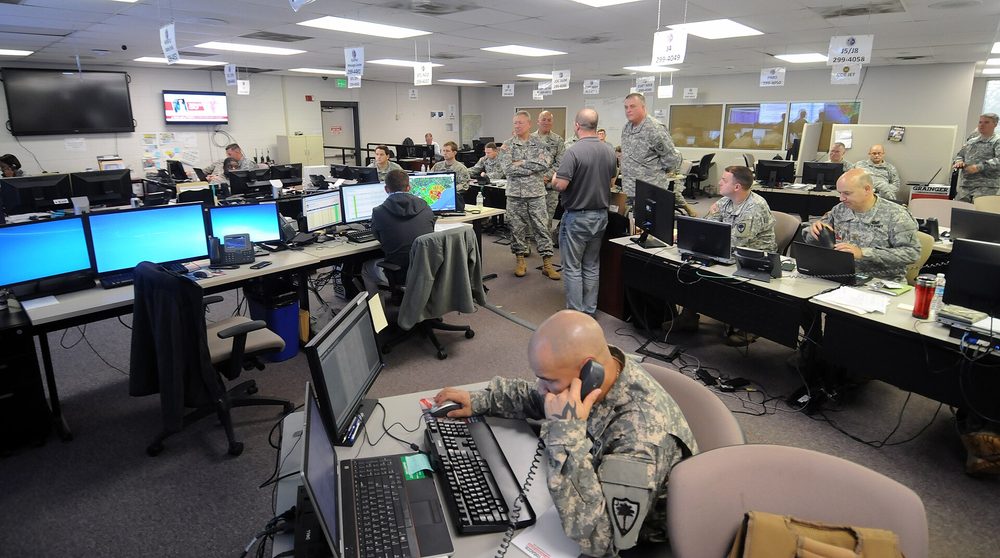An operations room lined with screens